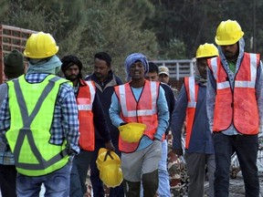 Rescuers walk near the site of an under-construction road tunnel that collapsed in mountainous Uttarakhand state, India, Friday, Nov. 17, 2023. Rescuers drilled deeper into the rubble of a collapsed road tunnel in northern India on Friday to fix wide pipes for 40 workers trapped underground for a sixth day to crawl to their freedom.