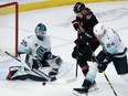 Seattle Kraken defenceman Jamie Oleksiak ties up Ottawa Senators left wing Brady Tkachuk as goaltender Joey Daccord makes a save.