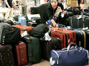 An Air Canada employee sifts through a pile of baggage from Toronto at the Edmonton International Airport in this Postmedia file photo.