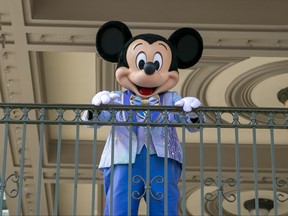 An actor dressed as Mickey Mouse greets visitors at the entrance to Magic Kingdom Park at Walt Disney World Resort, April 18, 2022, in Lake Buena Vista, Fla.
