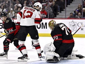 The puck bounces by the skate of New Jersey Devils centre Nico Hischier as Ottawa Senators goaltender Joonas Korpisalo makes a save