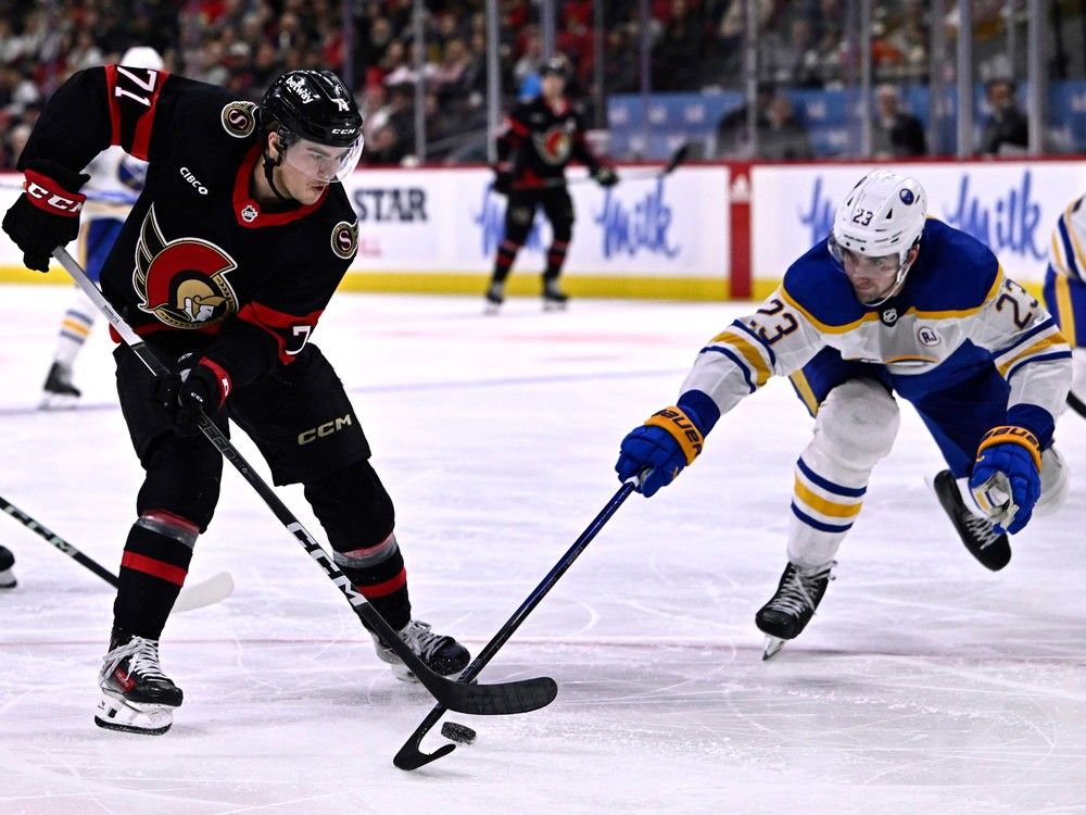 El centro de los Senadores de Ottawa, Ridly Greig (71), intenta controlar el disco mientras el defensa de los Buffalo Sabres, Mattias Samuelsson (23), avanza con su palo durante la acción de hockey de la NHL del segundo período en Ottawa, el domingo 31 de diciembre de 2023.
