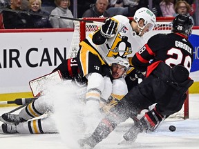 Pittsburgh Penguins centre Sidney Crosby (87) watches Ottawa Senators right wing Claude Giroux clear the puck as he crashes into his teammate, Jake Guentzel, during the first period at the Canadian Tire Centre on Saturday, Dec. 23, 2023.