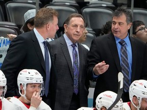 Ottawa Senators interim coach Jacques Martin, centre, listens to assistant coaches Daniel Alfredsson, left, and Jack Capuano during the second period of Thursday's game in Denver against the Colorado Avalanche.