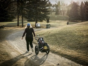 A golfer walks a cart path while playing a round at the Shaganappi Point golf course in Calgary, Tuesday, Dec. 5, 2023.