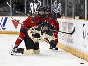 Ottawa's Akane Shiga (11) makes contact with Montreal's Laura Stacey (7) as they chase the puck behind Ottawa's net.