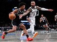 Dennis Smith Jr. of the Brooklyn Nets is defended by Damian Lillard of the Milwaukee Bucks.