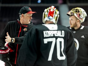 Ottawa Senators goaltending coach Zac Bierk talks to Anton Forsberg (31) and Joonas Korpisalo (70) during training camp.