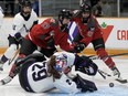 Ottawa's Gabbie Hughes tries to put the puck past Minnesota goalie Nicole Hensley as teammate Emily Clark looks on.
