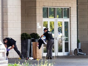 Investigators collect evidence outside the Infinity Convention Centre on Sept. 3, the day after gunshots killed two men and injured six others.