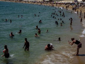 People cool off on a beach in Barcelona, Spain, Aug. 9, 2023.