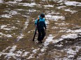 A skier walks down a patchy ski slope at Whistler, B.C., on Friday, December 29, 2023. Whistler has been experiencing warm weather and little snow this season, contributing to poor snow sports conditions during peak season.