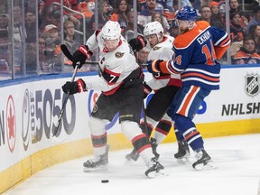 Ottawa Senators' Brady Tkachuk, Josh Norris and Edmonton Oilers' Mattias Ekholm battle for the puck