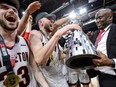 Carleton Ravens Connor Vreeken, Gebrael Samaha and coach Taffe Charles celebrate after the double-overtime win against St. Francis Xavier last March.