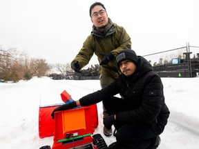 Boyan Zhou, left, and Siri Konakalla, research assistants at Carleton University, explain the components of 'Snobot' at Dow's Lake on Monday.