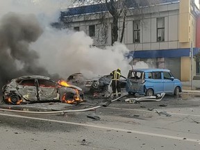 firefighters extinguish burning cars after shelling in Belgorod, Russia.