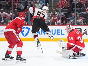 Ottawa Senators centre Shane Pinto jumps out of the way of a shot on Detroit Red Wings goaltender Alex Lyon as defenceman Olli Maatta looks on in the first period on Wednesday, Jan. 31, 2024, in Detroit.