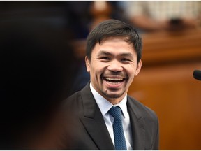 Philippine boxing icon-turned-senator Manny Pacquiao smiles as he is interpelated by a colleague after delivering his previlege speech on restoration of the death penalty during a session at the senate in Manila on August 8, 2016.