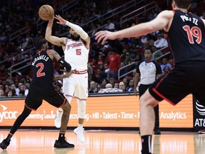 Fred VanVleet (5) of the Rockets passes the ball ahead of Jalen McDaniels (2) of the Raptors during first half NBA action at Toyota Center in Houston, Friday, Feb. 2, 2024.