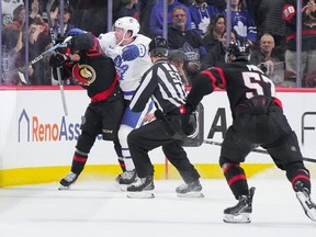 Morgan Rielly #44 of the Toronto Maple Leafs cross checks Ridly Greig