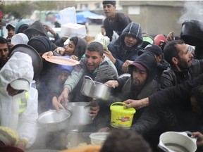 Palestinians line up for free food distribution in Khan Younis, Gaza Strip