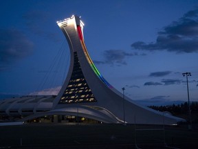 Quebec Tourism Minister Caroline Proulx says the provincial government will spend $870 million to replace the decaying roof of Montreal's Olympic Stadium. The Olympic Stadium is lit to the colours of the rainbow in solidarity with health-care workers in Montreal, on Monday, April 6, 2020.