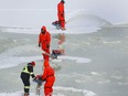 NCC crews flood the ice near the Flora Footbridge on the Rideau Canal in Ottawa Friday.