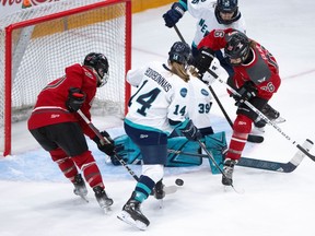 PWHL Ottawa forward Emily Clark (26) and PWHL New York defender Jaime Bourbonnais look for the puck during the first period in Ottawa on Wednesday, Feb. 28, 2024.