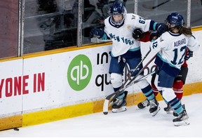 PWHL New York forward Emma Woods (67) and forward Chloe Aurard tie up PWHL Ottawa defender Amanda Boulier during the second period in Ottawa on Wednesday, Feb. 28, 2024.