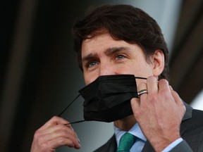 Prime Minister Justin Trudeau removes his mask to answer a question during a press conference outside the GLOBE Forum at the Convention Centre in Vancouver, B.C., on Tuesday, March 29, 2022.