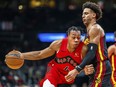 Toronto Raptors forward Scottie Barnes (4) drives the lane while being guarded by Atlanta Hawks forward Jalen Johnson Friday, Feb. 23, 2024, in Atlanta.