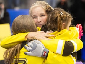Jennifer Jones hugs her daughters after the Scotties Tournament of Hearts final at WinSport Arena in Calgary on Sunday, Feb. 25, 2024.
