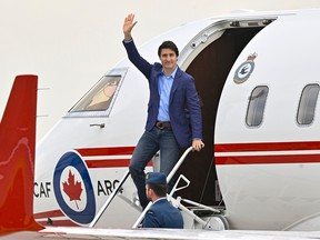 Prime Minister Justin Trudeau waves as he steps off a plane in June 2023.