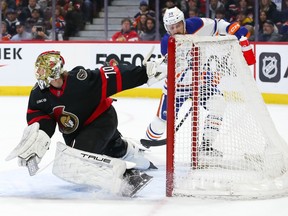 Joonas Korpisalo of the Ottawa Senators makes a pad save against Sam Carrick of the Edmonton Oilers.