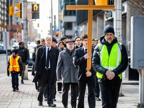Several hundred participants attended the Way of the Cross procession through downtown Ottawa on Good Friday. The group left the Saint Patrick's Basilica making their first stop at the Supreme Court of Canada. Benedict MacDonald carried the large wooden cross Friday morning during their walk. Ashley Fraser/Postmedia