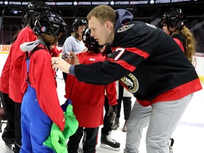 Brady Tkachuk signs jerseys during the Melnyk Skate for Kids at the Canadian Tire Centre in January 2024.