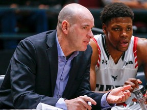 Dave Smart chats with Alain Louis on the bench in 2020 while he was still the head coach of the Carleton Ravens.