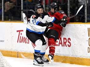 Toronto's Emma Maltais (27) sends Ottawa's Ashton Bell (21) into the boards during the first period in Ottawa on Saturday, March 2, 2024.