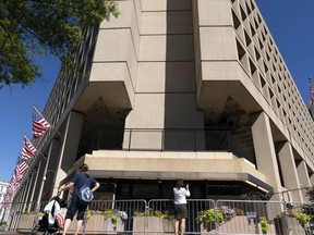 People take photos of the FBI building headquarters in Washington, Aug. 13, 2022.