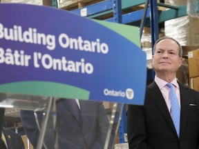 Ontario Finance Minister Peter Bethlenfalvy listens to Ontario Premier Doug Ford speak after touring the Oakville Stamping and Bending Limited facility in Oakville, Ont., on Wednesday, March 22, 2023.