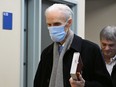 Former Quebec Court of Appeal judge Jacques Delisle, centre, walks to the courtroom in the Quebec City courthouse, Thursday, March 14, 2024. Delisle's son Jean Delisle, right, walks behind.