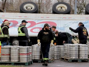 Workers clear beer kegs from the Highway 401 eastbound on-ramp in Brockville on Friday morning