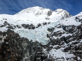 A glacier sits between mountains covered in snow in the Mount Aspiring National Park located near Queenstown on the South Island of New Zealand on Oct. 20, 2023. New Zealand's glaciers are shrinking as ice melts at an accelerating rate, a top government scientist warned March 25, 2024.