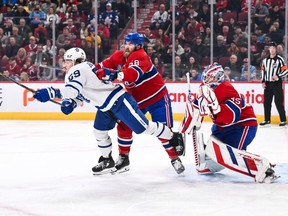 Canadiens' David Savard (58) checks Tyler Bertuzzi (59) of the Toronto Maple Leafs in front of goaltender Sam Montembeault during the first period at the Bell Centre on Saturday, April 6, 2024, in Montreal.