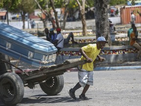 A man transports a coffin using a cart in Port-au-Prince, Haiti, Friday, March 22, 2024.
