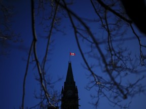 The Canada flag catches the morning light on the Peace Tower on Parliament Hill in Ottawa on Tuesday, April 16, 2024.