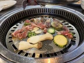 Zucchini, king oyster mushrooms and thinly sliced marinated lamb shoulder on a table top grill at Takumi BBQ restaurant on Merivale Road