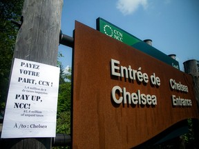 An August 2021 file photo shows the kind of sign put up by Chelsea-area residents regarding the Gatineau Park tax dispute with the National Capital Commission.