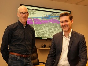 Randal Rodger, left, program manager of geospatial analytics, technology and solutions, and Court Curry, manager of right of way, heritage and urban design services, demonstrate Ottawa's virtual twin on the screen behind them.