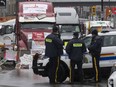 Police officers keep an eye on protest trucks, in Ottawa, Thursday, Feb. 17, 2022.